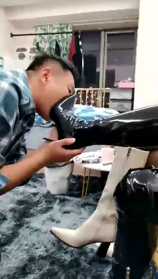 Pair of goddess black and white boots playing humble dog licking